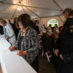 a person signs a steel beam for the student center at Ƶ